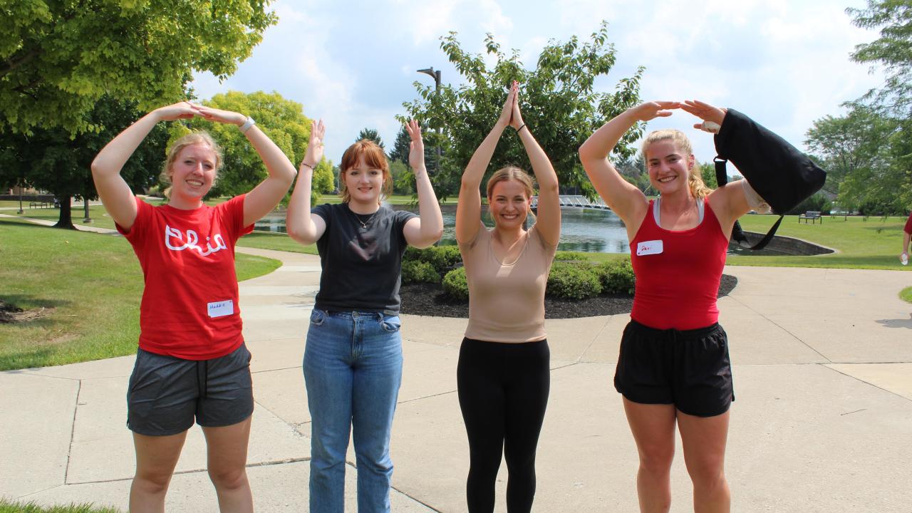 four women spelling OHIO with arms