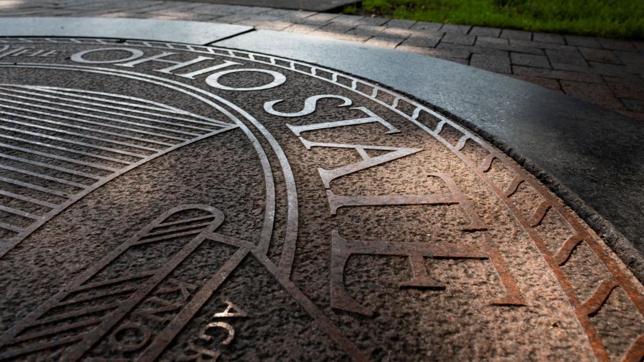 sun reflecting of university seal on ground