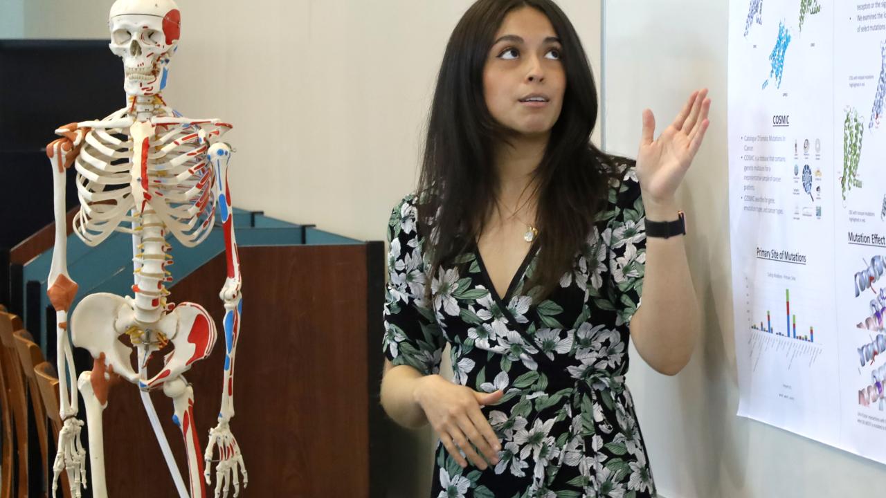 woman presenting research next to skeleton