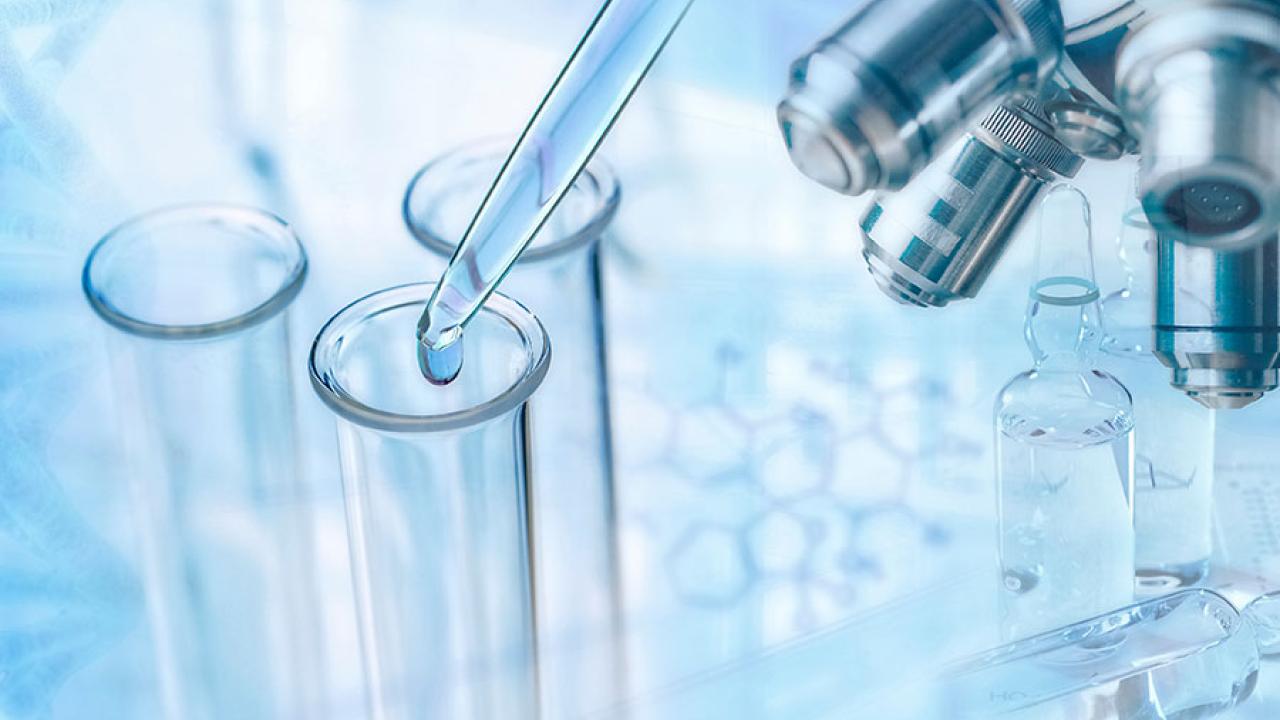 test tubes and microscope on light blue background